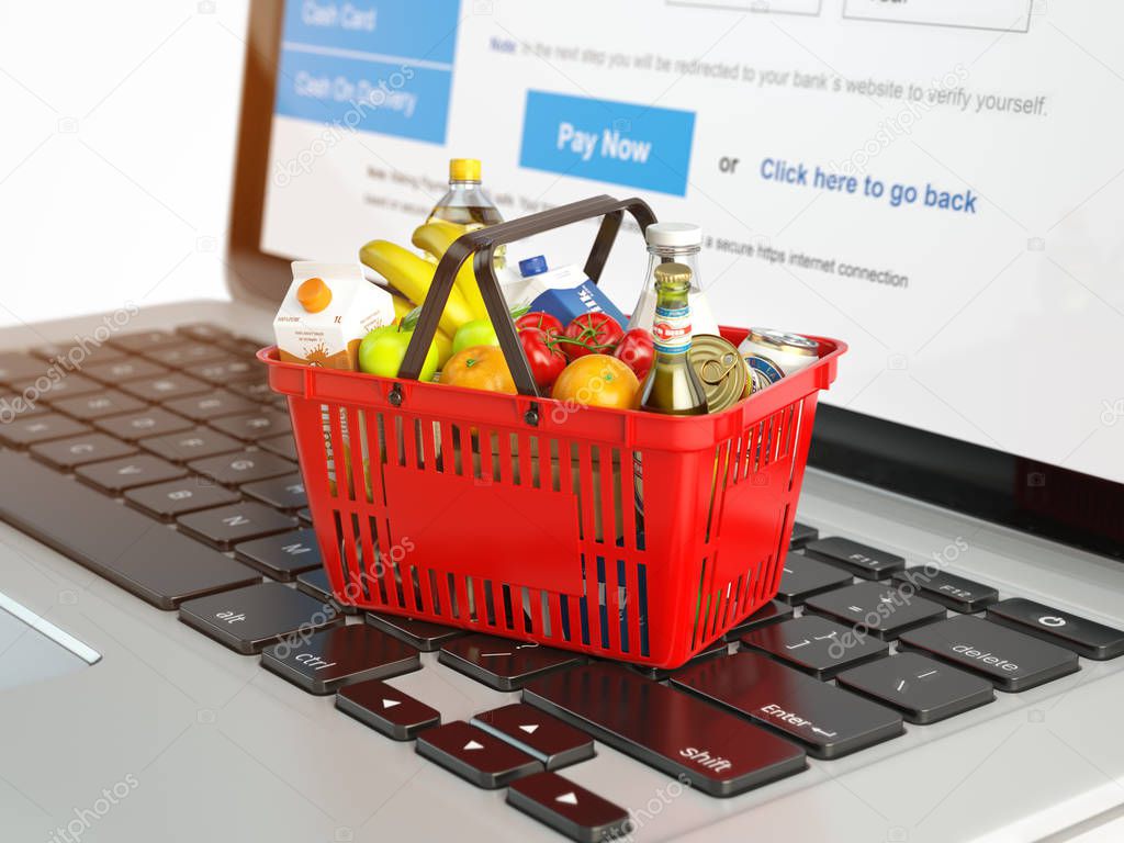 Shopping basket with variety of grocery products ion laptop keyb