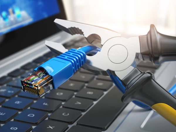 Tangen snijden lan netwerk computer kabel over laptop toetsenbord. — Stockfoto