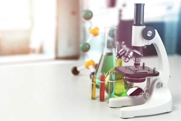 Мікроскоп з лабораторним скляним посудом, колбами та стовбурами. Наукова праця — стокове фото