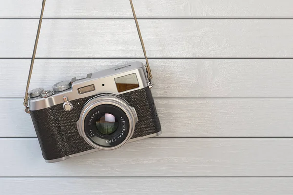 Vintage retro foto câmera pendurada na parede de madeira branca . — Fotografia de Stock
