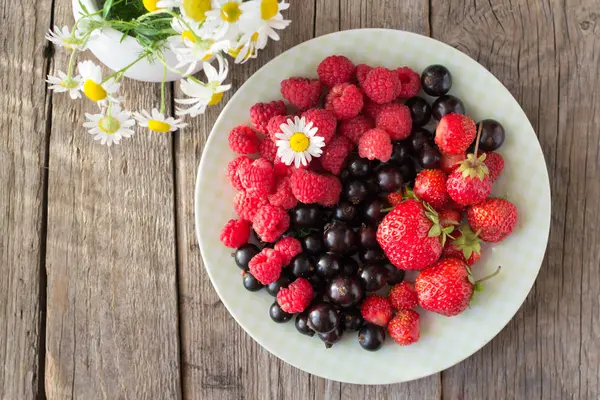 Различные ягоды на тарелке — стоковое фото