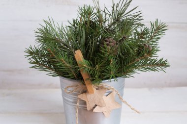 Beyaz ahşap zemin üzerinde köknar ağacı dalları ve koni buketi