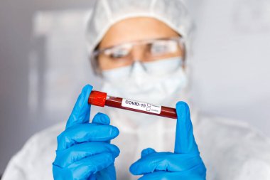 Covid 19 Coronavirus, Coronavirus araştırma laboratuarındaki bilim kadını doktor biyolojik tehlike koruma giysileri elinde bulunan tüpteki kanı enfekte etti. Coronavirus Covid-19 aşı araştırması