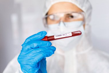 Covid 19 Coronavirus, Coronavirus araştırma laboratuarındaki bilim kadını doktor biyolojik tehlike koruma giysileri elinde bulunan tüpteki kanı enfekte etti. Coronavirus Covid-19 aşı araştırması