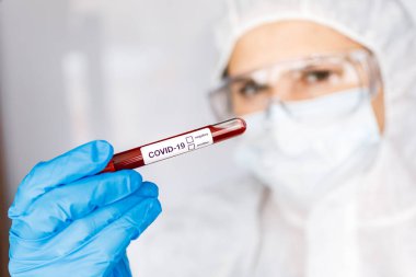 Covid 19 Coronavirus, Coronavirus araştırma laboratuarındaki bilim kadını doktor biyolojik tehlike koruma giysileri elinde bulunan tüpteki kanı enfekte etti. Coronavirus Covid-19 aşı araştırması