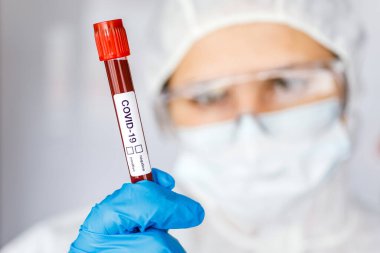 Covid 19 Coronavirus, Coronavirus araştırma laboratuarındaki bilim kadını doktor biyolojik tehlike koruma giysileri elinde bulunan tüpteki kanı enfekte etti. Coronavirus Covid-19 aşı araştırması