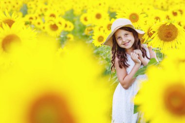 Ayçiçeği tarlasında ayçiçekleriyle oynayan tatlı kız (çocuk)