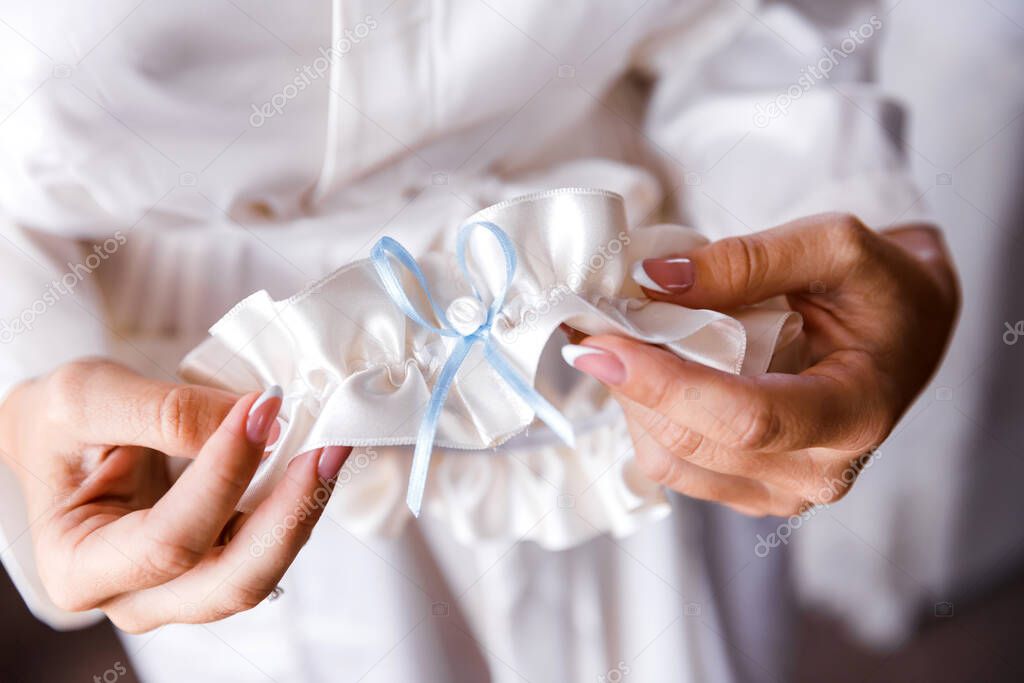 Bride holds of bride garter. The concept of morning training for the wedding. Wedding accessories. Garter Bride. Close-up