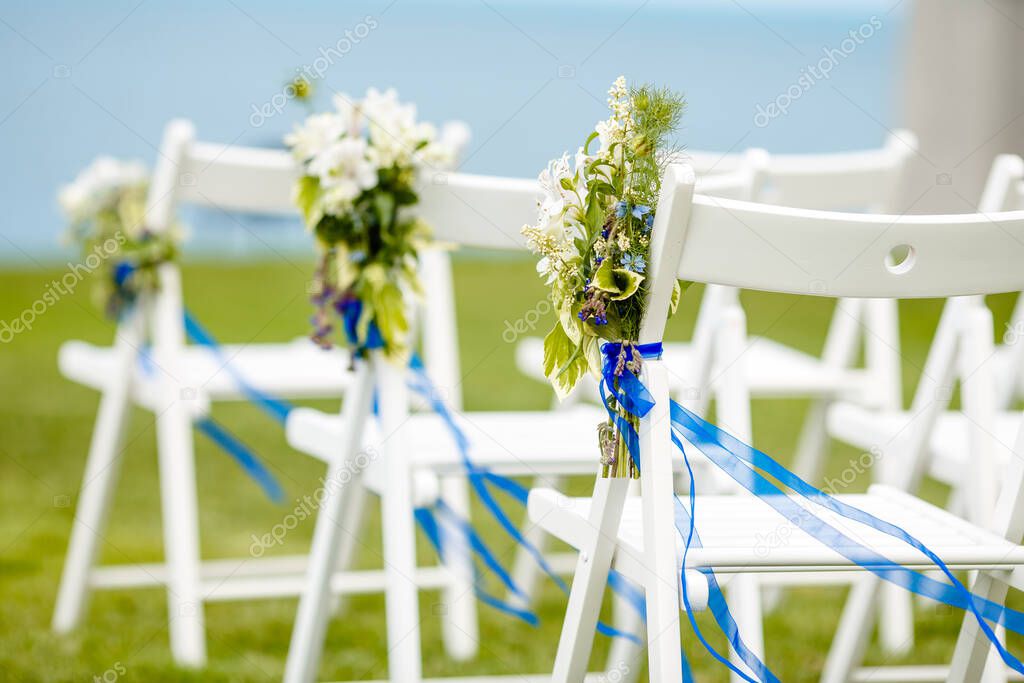 Original wedding floral decoration.Wedding chairs against the sea background