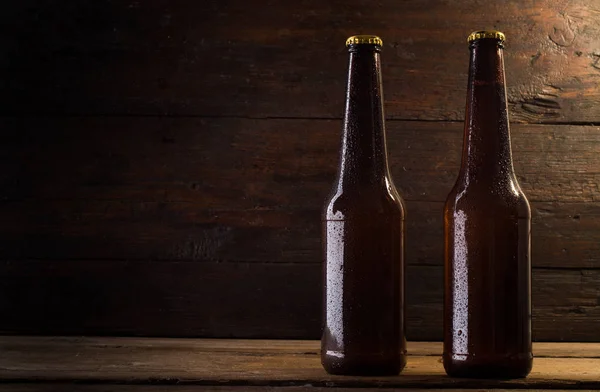 Botella de cerveza sobre un fondo de madera — Foto de Stock