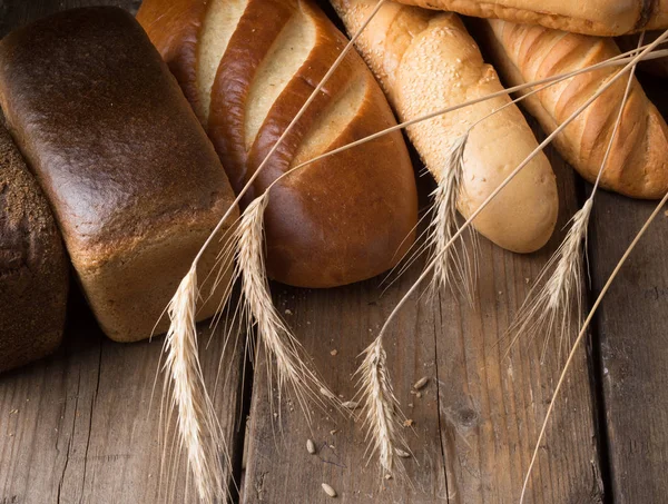 Différents types de pain sur une table en bois — Photo