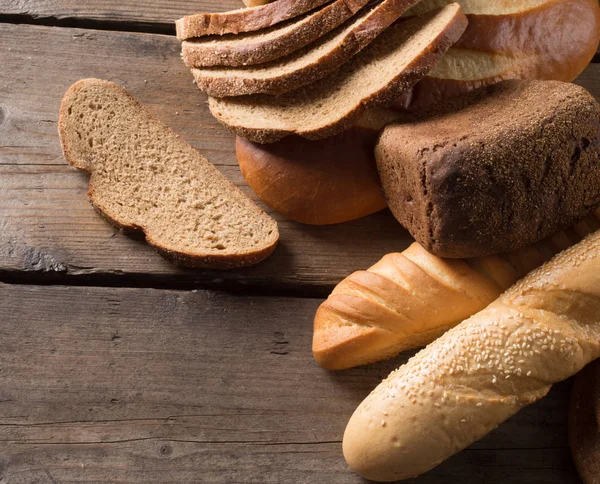 Diferentes tipos de pan en una mesa de madera —  Fotos de Stock