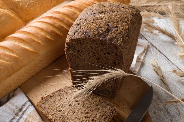 Olika typer av bröd på ett träbord — Stockfoto