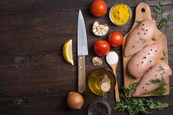 Rohes Hühnerfleisch auf Holzbrett auf dem Tisch — Stockfoto