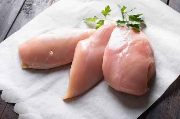 Filet z mięsa surowego kurczaka na podłoże drewniane — Zdjęcie stockowe