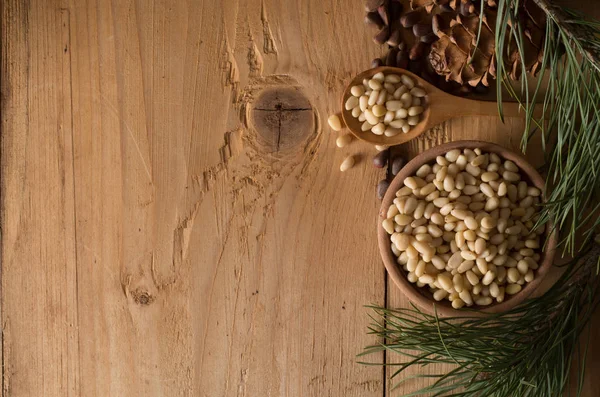 Orzechów cedrowych i stożki na drewnianym stole — Zdjęcie stockowe