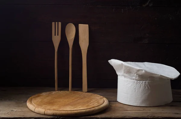 Chapéu de Chef em uma velha mesa de madeira. Contexto conceitual sobre o — Fotografia de Stock