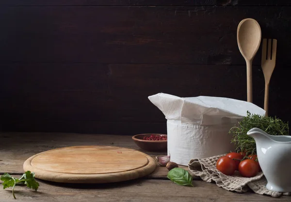 Chef's hat on an old wooden table. Conceptual background on the — Stock Photo, Image