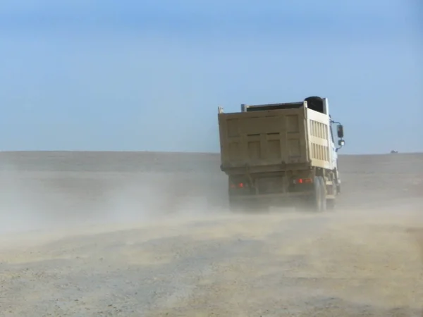 Camión volquete en un camino de tierra . — Foto de Stock