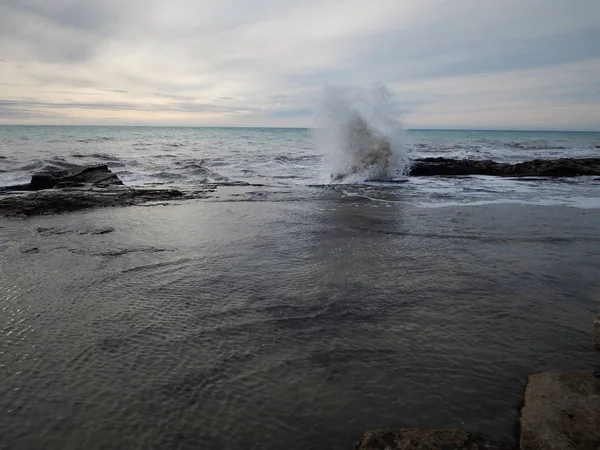 Bølgen sprekker mot klippene . – stockfoto