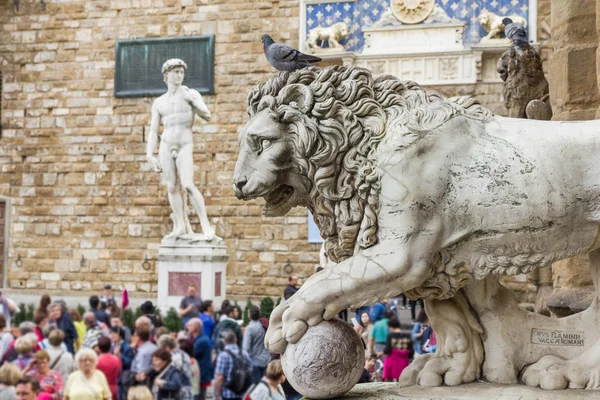 Piazza della Signoria with a lion statue and the replica of Michelangelo's David — Stock Photo, Image