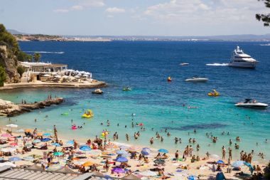 Palma, İspanya - 13 Ağustos 2017: İnsanlar Mallorca 'daki Illetes plajında güneşli günün tadını çıkarıyorlar. Adanın doğu kıyısında yer alan sahil, Illetas veya Ses Illetes olarak da bilinir..