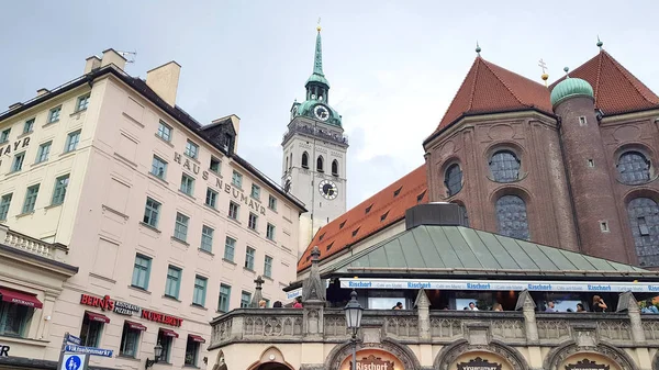 ミュンヘン ドイツ 2019 人々は市内中心部で食事や飲酒 背景に聖ピーターズ教会と 市内にはビアホールや庭園がある — ストック写真