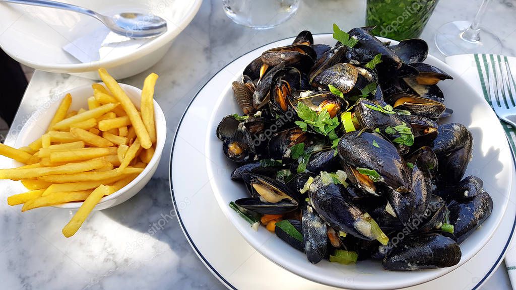 Big typical Mediterranean mussels plate with fries