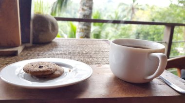 Kahve ve kurabiye Ubud, Bali, Endonezya 'da bir ormanda bir masada servis edilir.