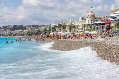 Güzel, Fransa - 23 Ağustos 2015: Turistler sahilde güzel havanın tadını çıkarıyorlar. Sahil ve liman bulvarı, Promenade des Anglais, neredeyse tüm yıl dolu..