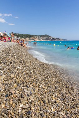 Güzel, Fransa - 23 Ağustos 2015: Turistler sahilde güzel havanın tadını çıkarıyorlar. Sahil ve liman bulvarı, Promenade des Anglais, neredeyse tüm yıl dolu..