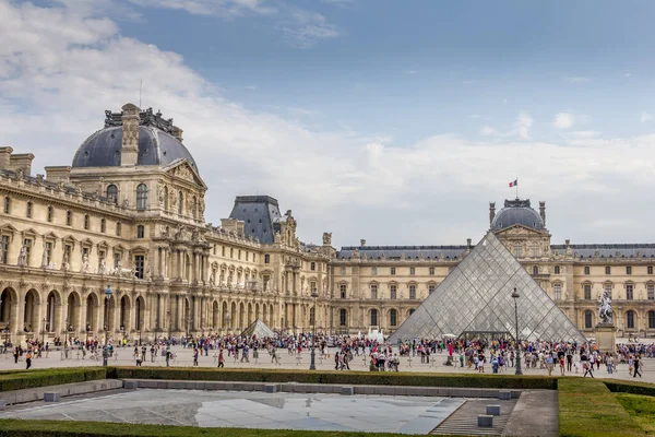 Paris, Fransa - 20 Eylül 2012: Louvre Müzesi 'nin önünde yürüyen insanlar. Louvre, her yıl 8 milyondan fazla ziyaretçi alan dünyanın en büyük müzelerinden biri..