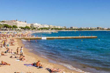 Cannes, Fransa - 13 Eylül 2012: Turistler Fransa 'nın Cannes plajında güzel havanın tadını çıkarıyorlar. Plaj ve rıhtım bulvarı, La Croisette, yıl boyunca doludur.