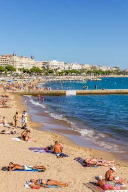 Cannes, Fransa - 13 Eylül 2012: Turistler Fransa 'nın Cannes plajında güzel havanın tadını çıkarıyorlar. Plaj ve rıhtım bulvarı, La Croisette, yıl boyunca doludur.