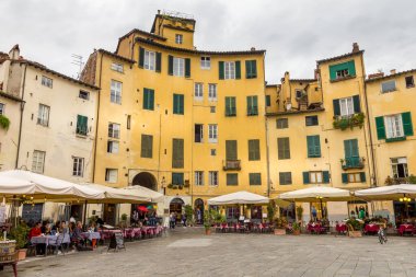 Lucca, İtalya - 25 Ekim 2016: Piazza del Anfiteatro 'daki restoranlarda insanlar. Meydanın eski Roma amfitiyatrosunun eliptik bir şekli vardır..