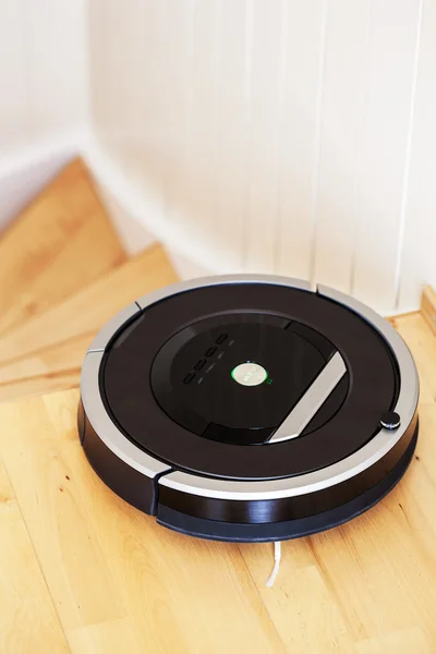 Robotic vacuum cleaner on laminate wood floor smart cleaning tec — Stock Photo, Image