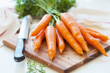 raw carrot vegetable on wooden chopping board clipart