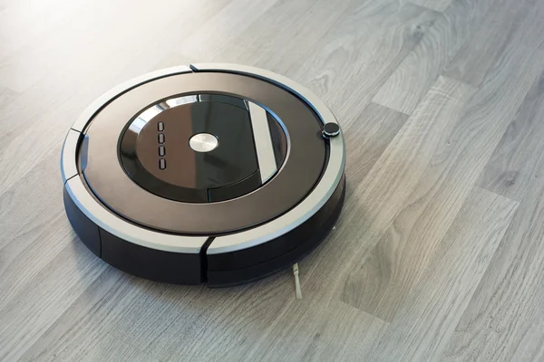 Ρομποτική ηλεκτρική σκούπα στο φυλλόμορφο ξύλινο πάτωμα για έξυπνη καθαρισμού ΣΕΚ — Φωτογραφία Αρχείου