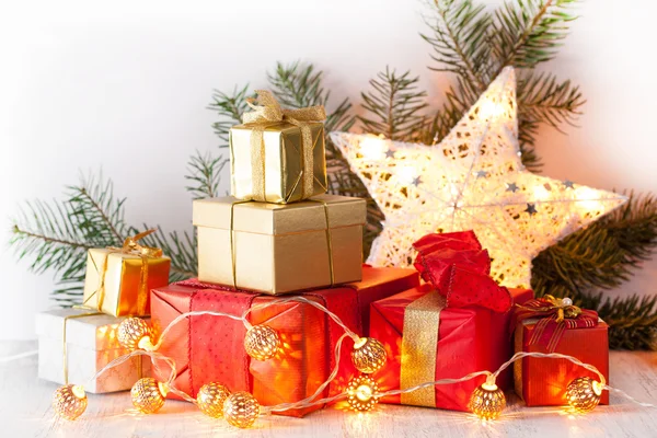 Červená a zlatá vánoční dárková krabice a dekorace světlo — Stock fotografie