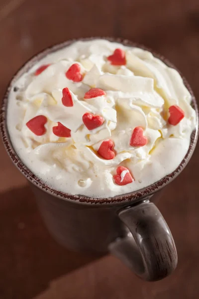 Secangkir kopi dengan krim kocok dan hati merah — Stok Foto