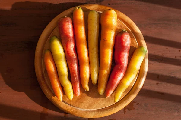 Сырой красочный овощ морковь на деревянном фоне — стоковое фото