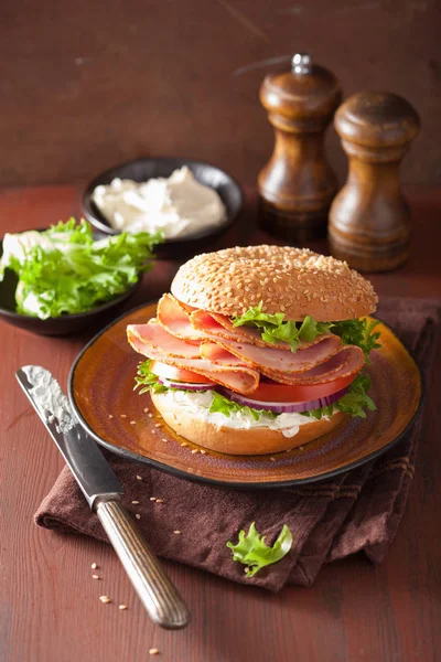 Sanduíche de presunto em bagel com creme de queijo cebola de tomate — Fotografia de Stock