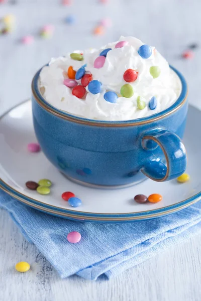 Koffie met opgeklopte slagroom en kleurrijke chocolade druppels — Stockfoto