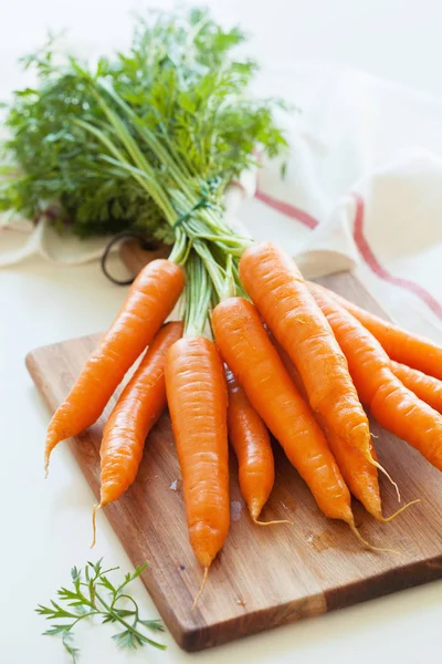 Légumes aux carottes crues sur planche à découper en bois — Photo