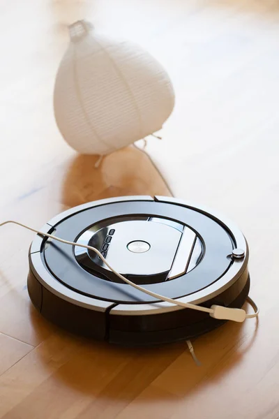 Robotic vacuum cleaner on laminate wood floor smart cleaning tec — Stock Photo, Image