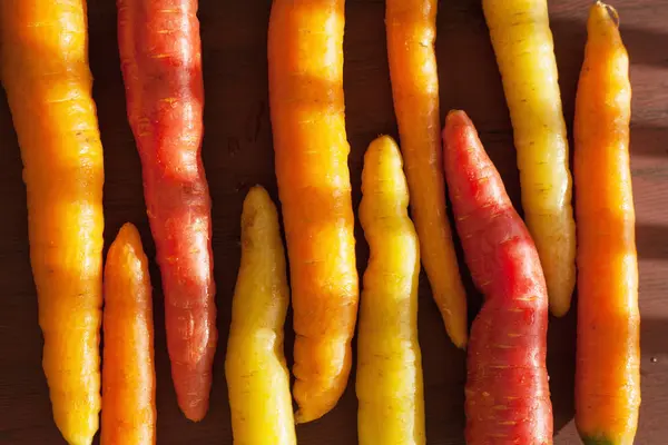 Surový barevné mrkev zelenina na dřevěné pozadí — Stock fotografie