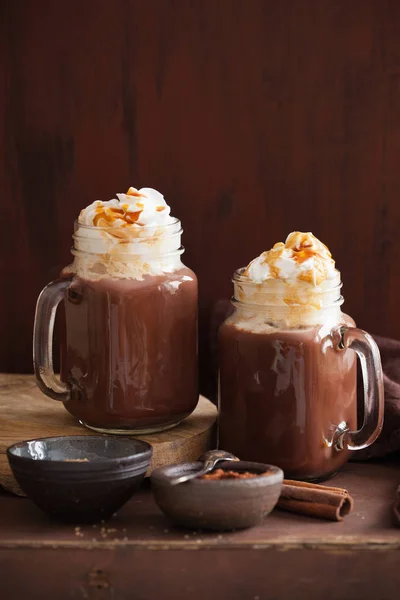 Chocolat chaud avec caramel à la crème fouettée dans un bocal de maçon — Photo