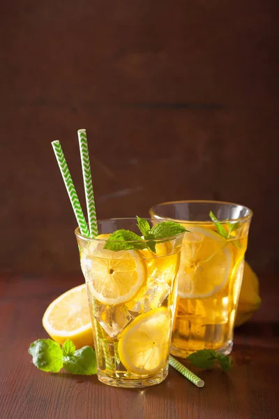 Té helado con limón y menta sobre fondo rústico oscuro —  Fotos de Stock