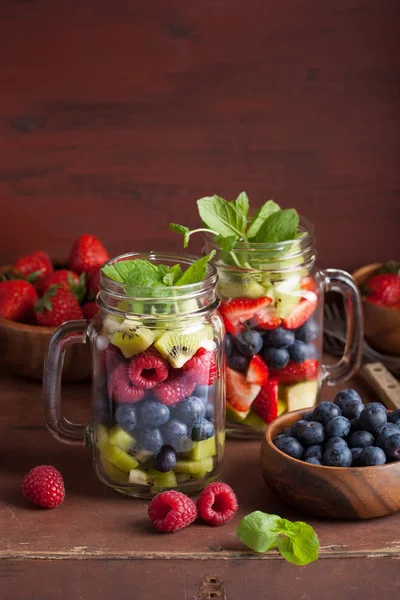 Salada de frutas em frasco de pedreiro morango hortelã de maçã kiwi de mirtilo — Fotografia de Stock