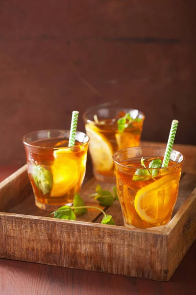 Té helado con limón y menta sobre fondo rústico oscuro —  Fotos de Stock